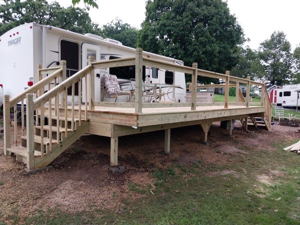 Full view of a raised travel trailer deck with rails and stairs