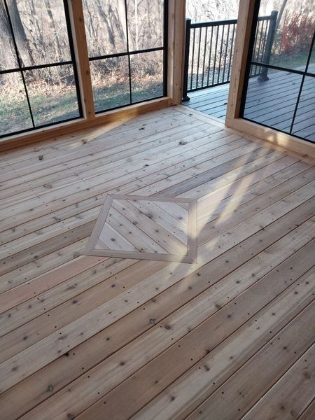 Cedar plank floor with inlay in a glass-walled room