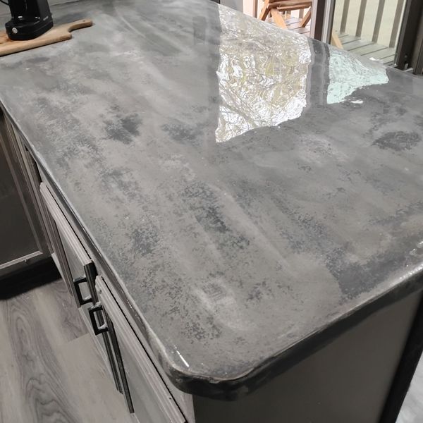 Close view of a polished gray microcement countertop with a rounded edge