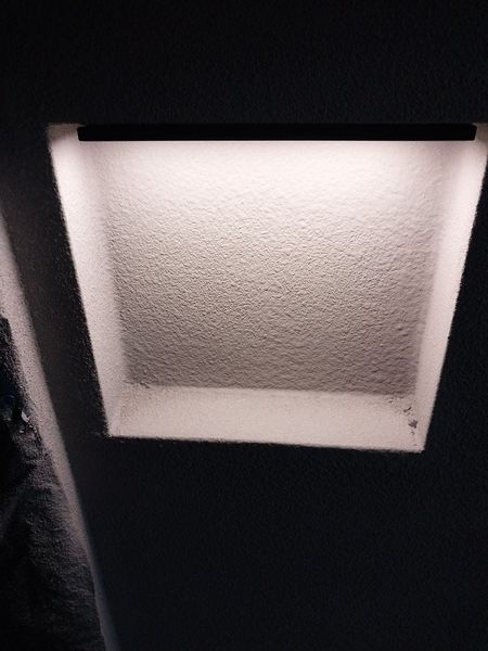 Recessed wall shelf finished in microcement, lit by a concealed LED strip