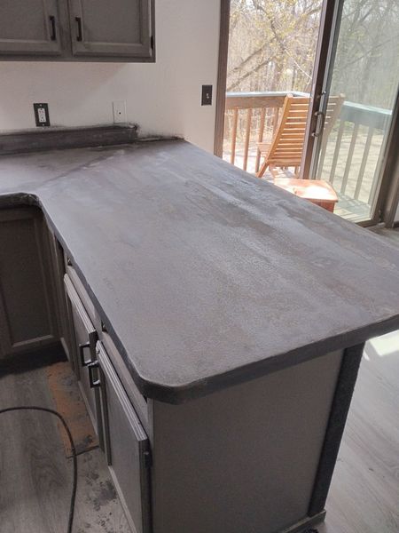 Dark microcement peninsula countertop with a smooth matte finish