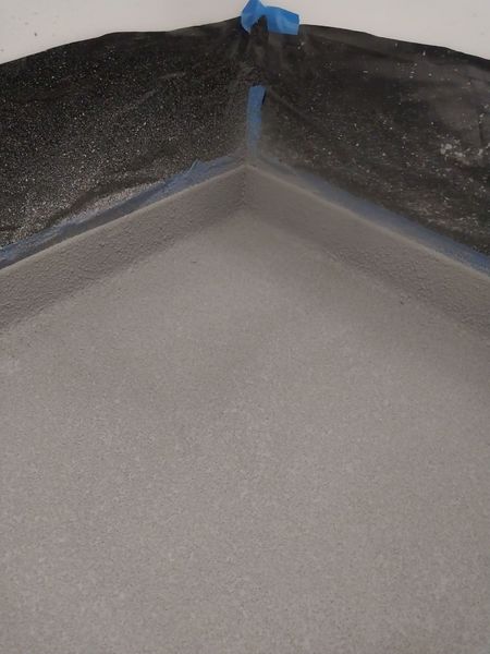 Shower base during microcement application, with coved corners